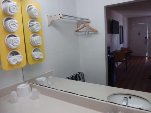 a bathroom with a mirror and a sink with towels at Motel 6-Warner Robins, GA in Warner Robins