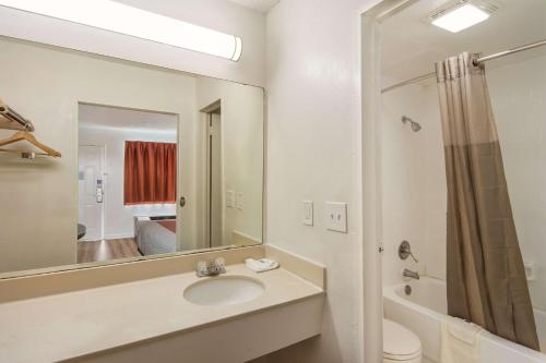 a bathroom with a sink and a toilet and a mirror at Motel 6-Warner Robins, GA in Warner Robins