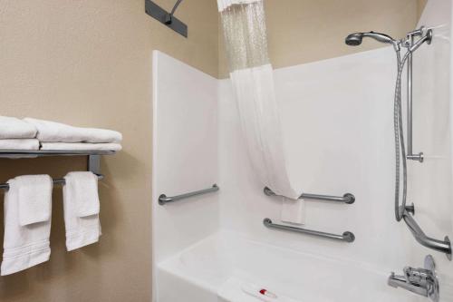 a bathroom with a shower and a bath tub with towels at Ramada by Wyndham Elizabethtown in Elizabethtown