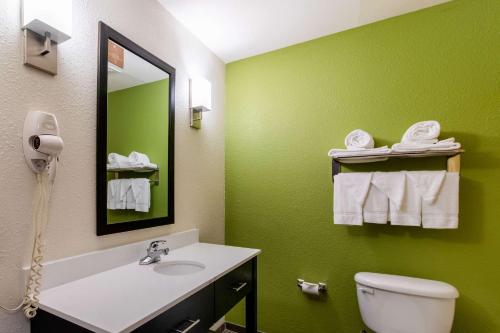 a green bathroom with a sink and a toilet at Sleep Inn & Suites Near Fort Cavazos in Killeen