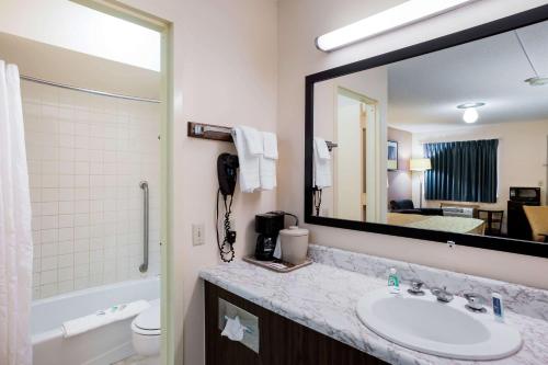 uma casa de banho com um lavatório e um espelho grande em Rodeway Inn Sergeant Bluff - Sioux City em Sergeant Bluff