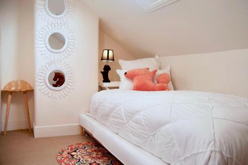 a bedroom with a white bed with a teddy bear on it at Lotus Gogh Apartment in Hobart