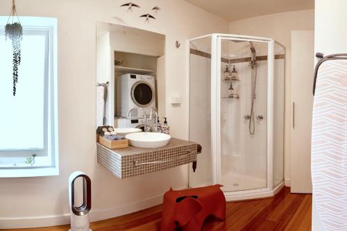 W łazience znajduje się umywalka i prysznic. w obiekcie Lotus Gogh Apartment w mieście Hobart