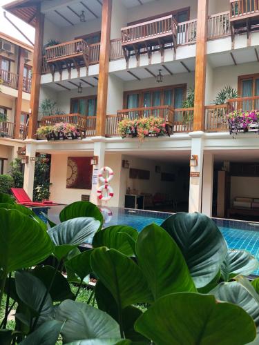 a resort with a swimming pool and plants at Vieng Mantra Hotel in Chiang Mai