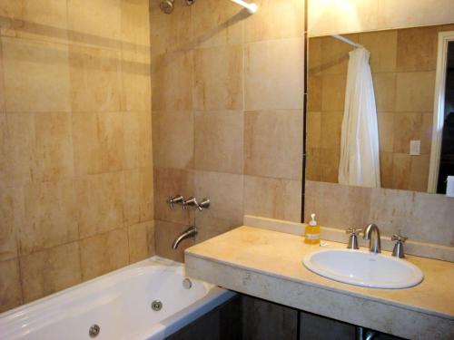 a bathroom with a sink and a bath tub at Cariló Sul Mare in Carilo