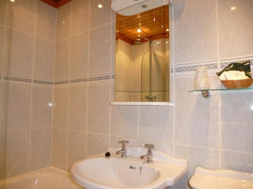 a bathroom with a sink and a toilet and a mirror at Somerton House Hotel in Lockerbie