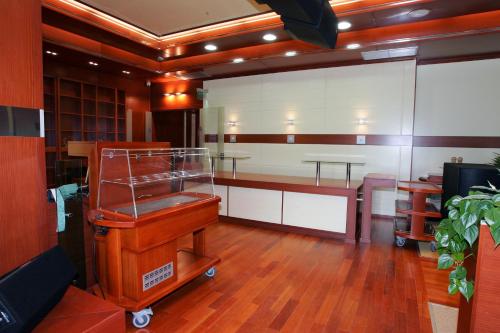 a large room with a table and a barber shop at Hotel Cezar Banja Luka in Banja Luka
