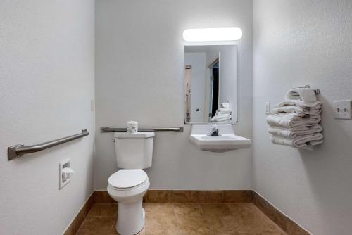 a bathroom with a toilet and a sink and a mirror at Quality Inn in Coraopolis