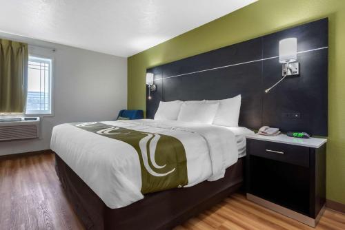 a hotel room with a large bed and a phone at Quality Inn in Coraopolis