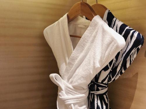 a group of white shirts hanging on a rack at Cheery Dragon Canal Hotel Hangzhou - Intangible Cultural Heritage Hotel in Hangzhou