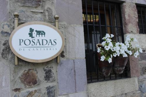 a sign on the side of a building with a window at Posada Rural Bistruey in Potes