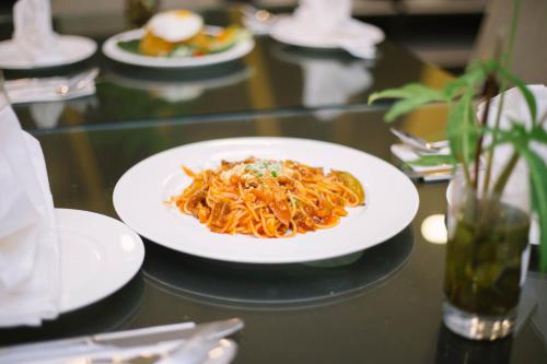 a white plate of pasta on a table at The Capital Residence Suites in Bandar Seri Begawan