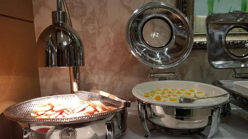 a kitchen counter with a pot and a pan with food at Symphony Hotel in Suwon