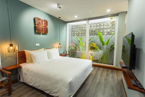 a bedroom with a large white bed and a window at An Bang beach Chay Villas in Hoi An