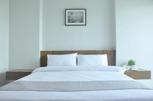 1 dormitorio con 1 cama grande con sábanas blancas en 24Residence Siriraj en Bangkok
