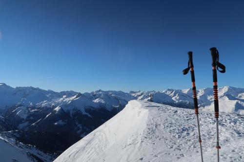 a snowy mountain with two ski poles on top of it at Appartementhaus Unterkofler in Grossarl