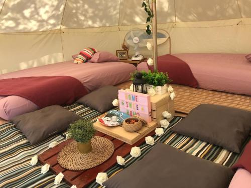 Glamping Kaki - Large Bell Tent في سنغافورة: غرفة بسريرين وطاولة بالنباتات