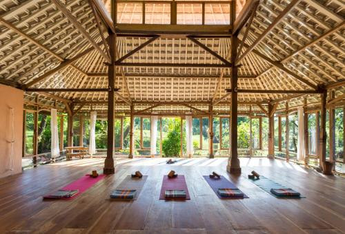 a yoga class in a pavilion with people in yoga mats at Prana Dewi Mountain Resort in Jatiluwih