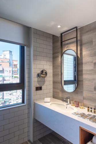 a bathroom with a sink and a mirror at Just Palace Hotel in Taipei