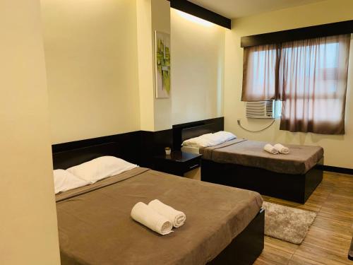 a hotel room with two beds and a window at Z Pension in Dumaguete