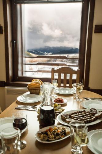 a table with plates of food and a window at Guest House Panorama in Gela