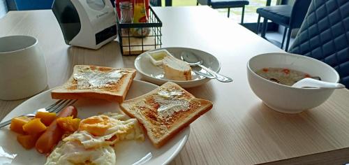 a plate of food with toast and a bowl of soup at Makan Resort in Kanchanaburi