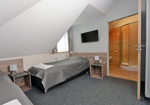 a hotel room with a bed and a television at Zajazd Aleksandria in Aleksandrów Łódzki