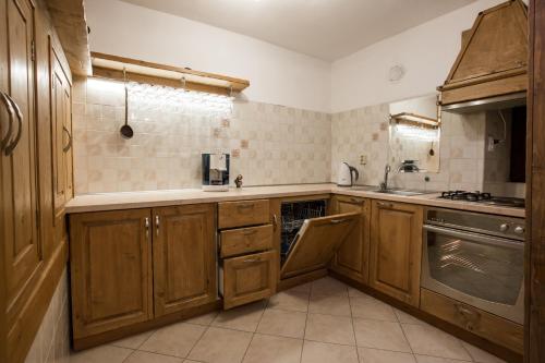 a kitchen with wooden cabinets and a stove top oven at Guest House Panorama in Gela