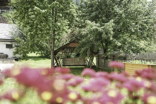 a gazebo in a yard with purple flowers at Ferienwohnung Moarhofer in Muhr