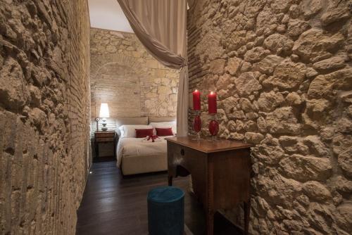 a bedroom with a bed and a table with red candles at Suite via Sulis 61 in Cagliari