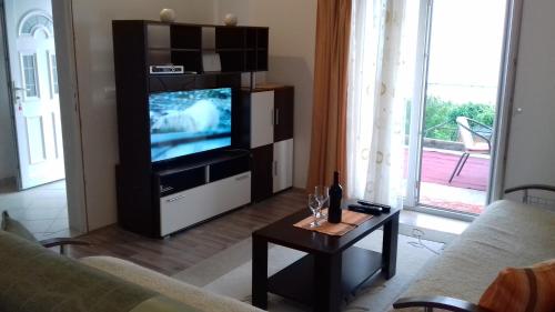 a living room with a tv and a table at Apartment Vuk i Novak in Ulcinj