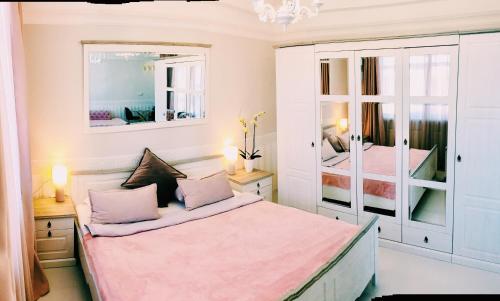 a bedroom with a bed and two mirrors at DeLight Apartments in Boryspilʼ