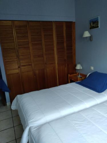 - une chambre avec un grand lit blanc et des placards en bois dans l'établissement Les lavandes, à Duilhac-sous-Peyrepertuse