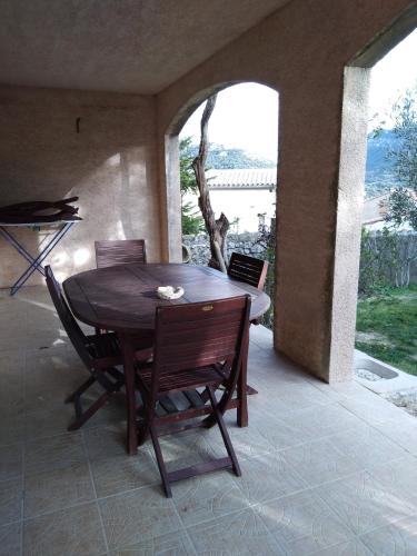 une table et des chaises en bois sur une terrasse dans l'établissement Les lavandes, à Duilhac-sous-Peyrepertuse