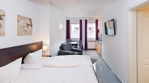 a hotel room with two beds and a chair at Boardinghouse - Stadtvilla Budget in Schweinfurt
