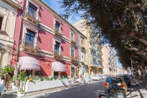 a pink building on the side of a street at B&B L'Infiorescenza new in Siracusa