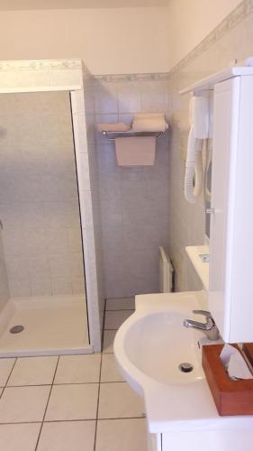 uma casa de banho branca com um chuveiro e um lavatório. em Berry Relais em Neuvy-Pailloux