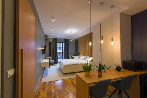 a bedroom with a bed and a desk and chairs at Urban Oasis Apartments with Parking in Bucharest