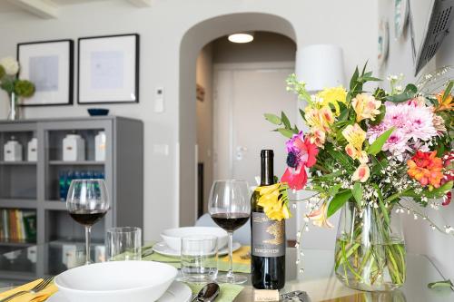a table with a bottle of wine and a vase of flowers at Rome as you feel - Grotta Pinta apartments in Rome