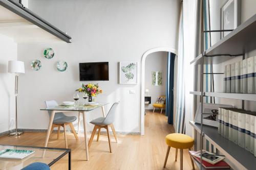 a dining room and living room with a table and chairs at Rome as you feel - Grotta Pinta apartments in Rome