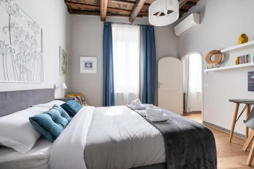 a bedroom with a large white bed with blue pillows at Rome as you feel - Grotta Pinta apartments in Rome
