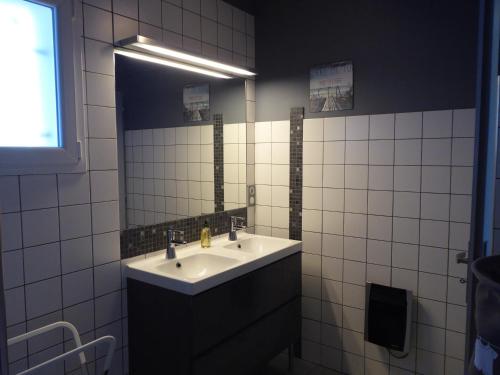 a bathroom with a sink and a mirror at Location au calme vue sur le canal du midi et la mer in Portiragnes