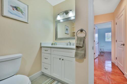 W łazience znajduje się toaleta, umywalka i lustro. w obiekcie Cocoa Beach Bungalow w mieście Cocoa Beach
