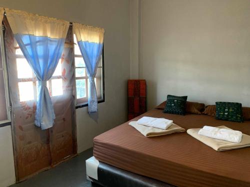 Un dormitorio con dos camas y una ventana. en J Giant Hostel, en Chiang Mai