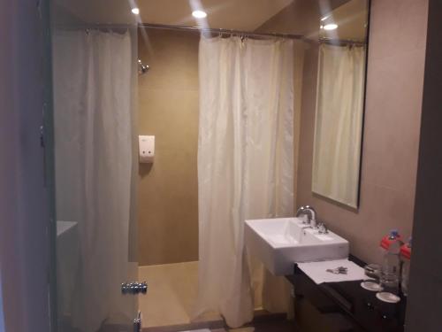 a bathroom with a shower curtain and a sink at Amaris Hotel Ambon in Ambon
