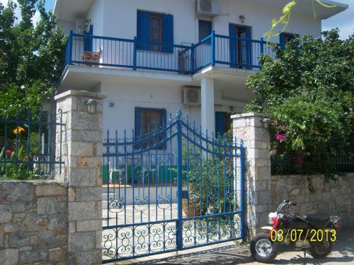 a scooter parked in front of a gate in front of a house at Smile Stella Studios in Skopelos Town