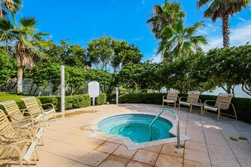 a patio with a hot tub and chairs and palm trees at 1000 Cinnamon Beach in Palm Coast