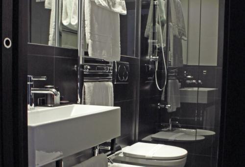 a bathroom with a white sink and a toilet at LHP Hotel Napoleon in Milan