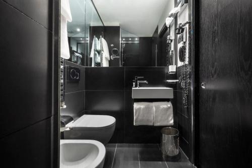 a black and white bathroom with a toilet and a sink at LHP Hotel Napoleon in Milan