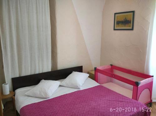a bedroom with a pink bed with white pillows at Apartments Gina in Trogir
